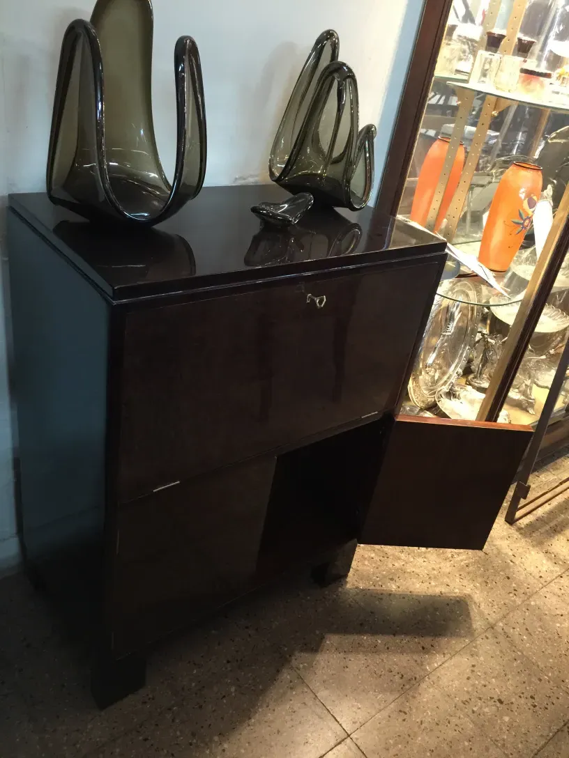 Mueble bar antiguo con detalles ornamentales y ambiente elegante.