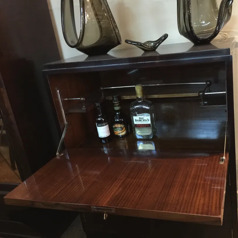 古董酒吧家具，木质表面和可见瓶子，装饰着优雅的物品。