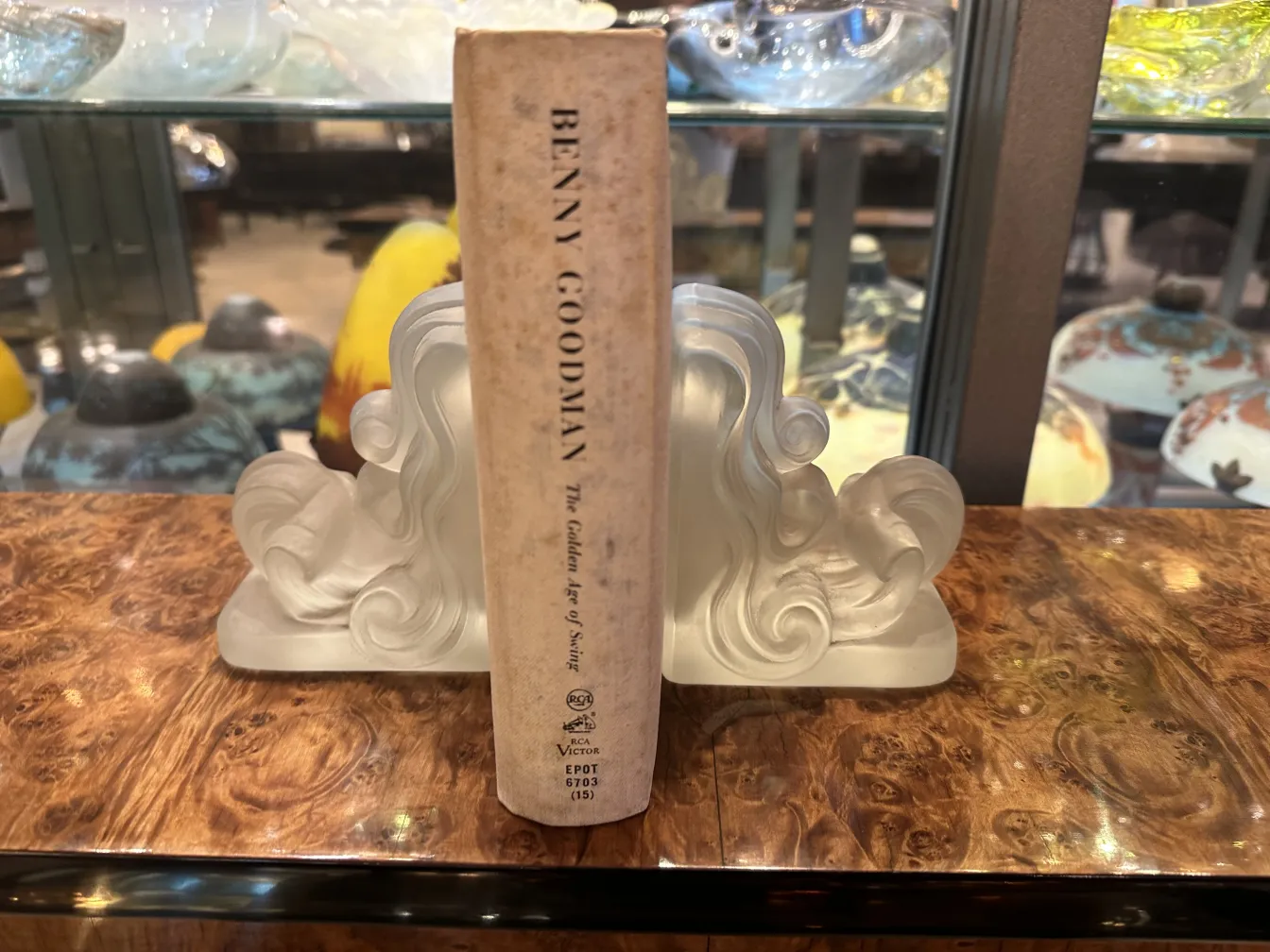 Fermalibri in stile Art Nouveau con dettagli ondulati su una superficie in legno.