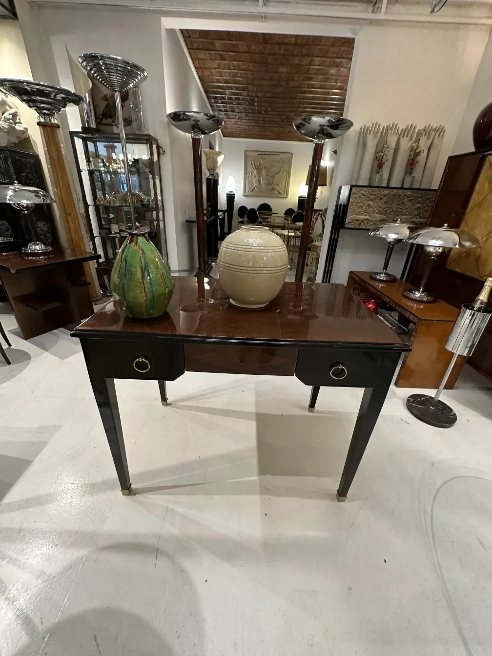 Escritorio antigo com acabamento brilhante e detalhes dourados, decorado com acessórios modernos.