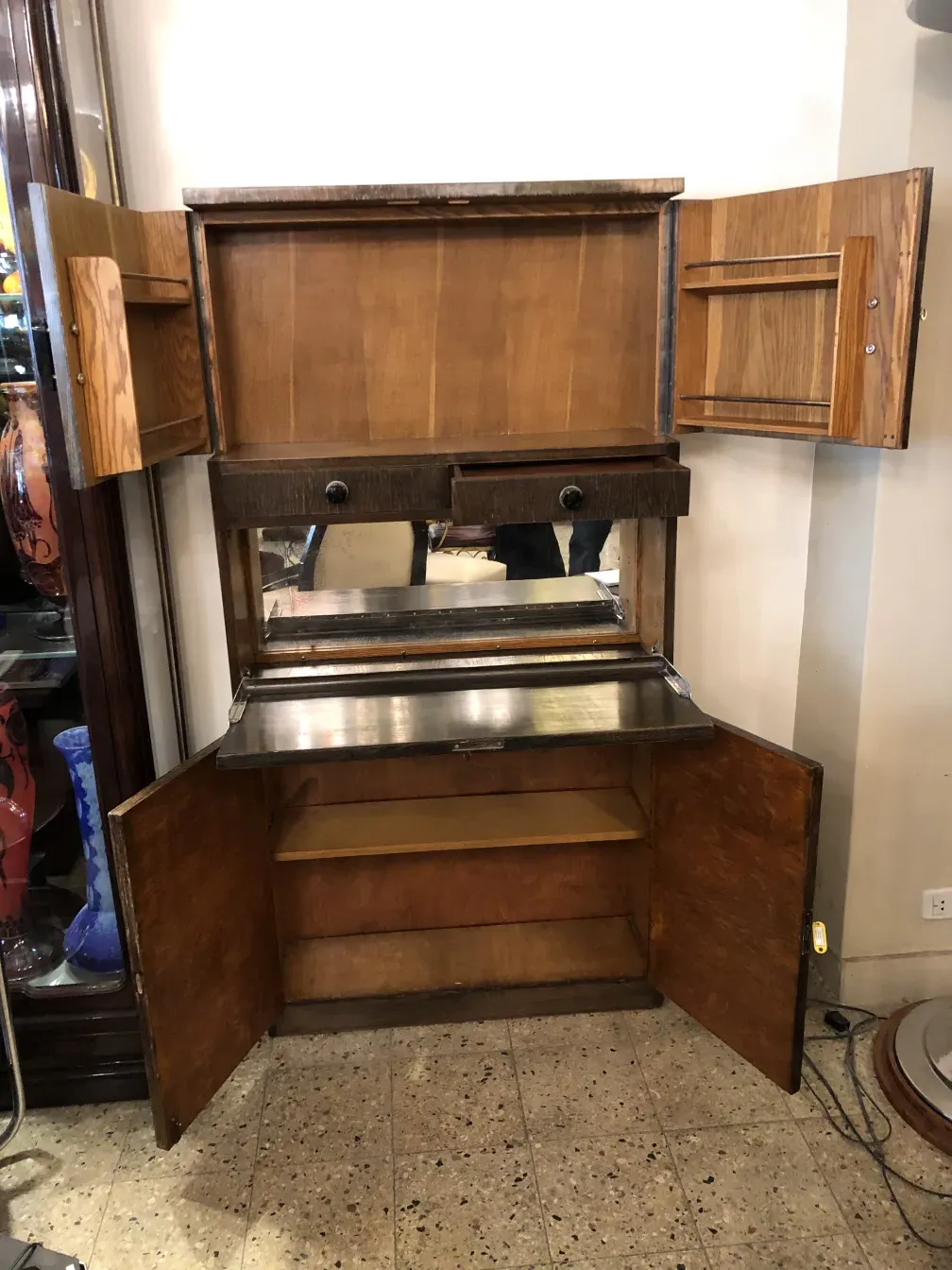 Mobile bar antico con specchio e dettagli in legno chiaro in un ambiente accogliente.