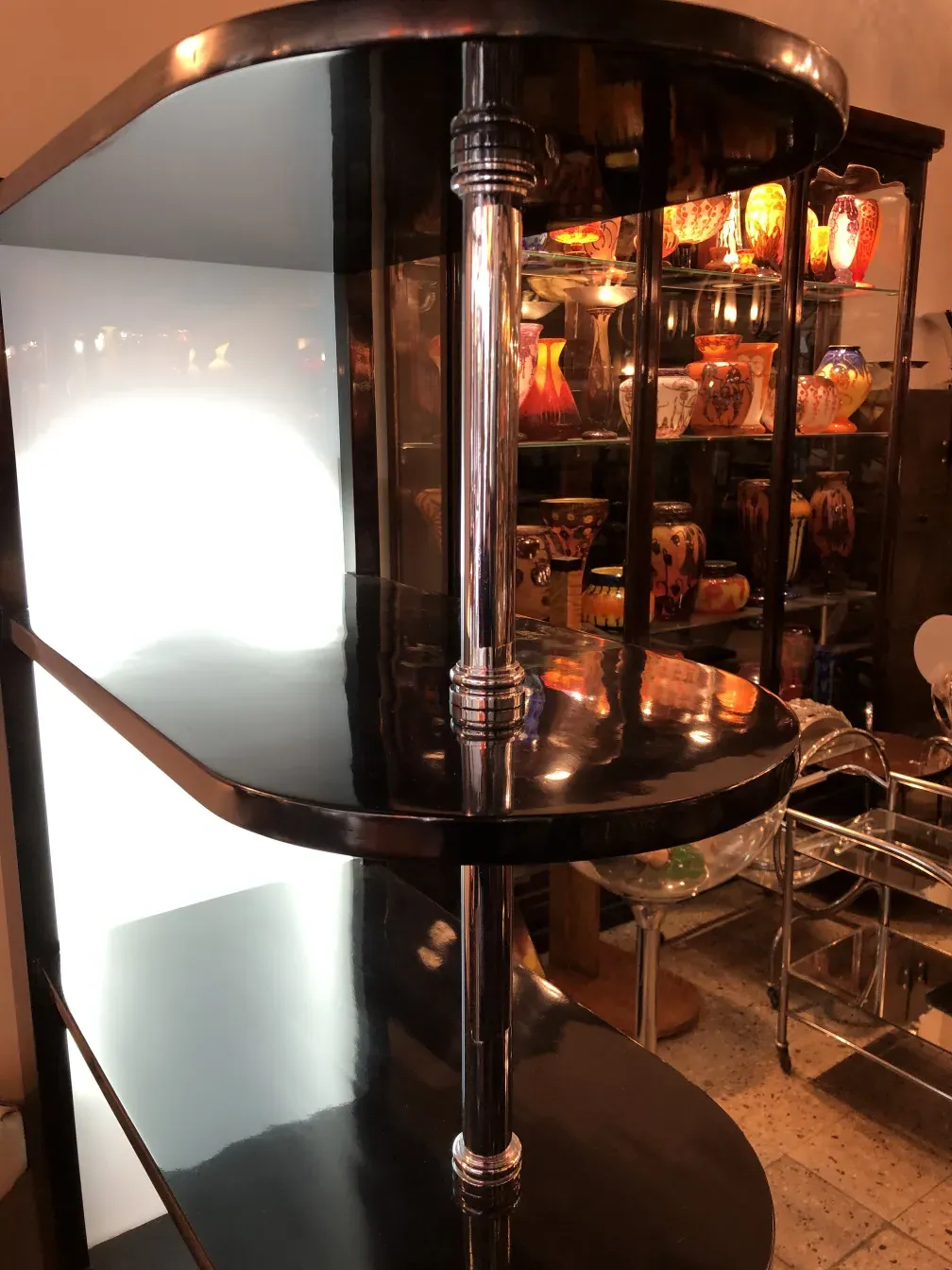 古董酒吧柜有深色镜子和浅色背景，装饰着彩色玻璃杯。