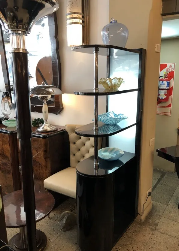 Antiker Cocktailschrank mit dekorativen Regalen und Lampe.