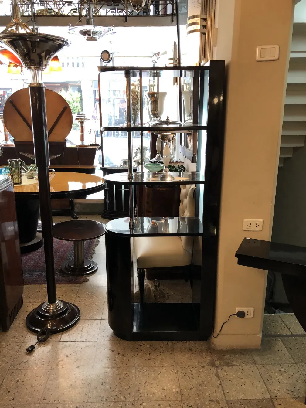 Bar aparador antigo com detalhes em madeira, cercado por objetos decorativos.