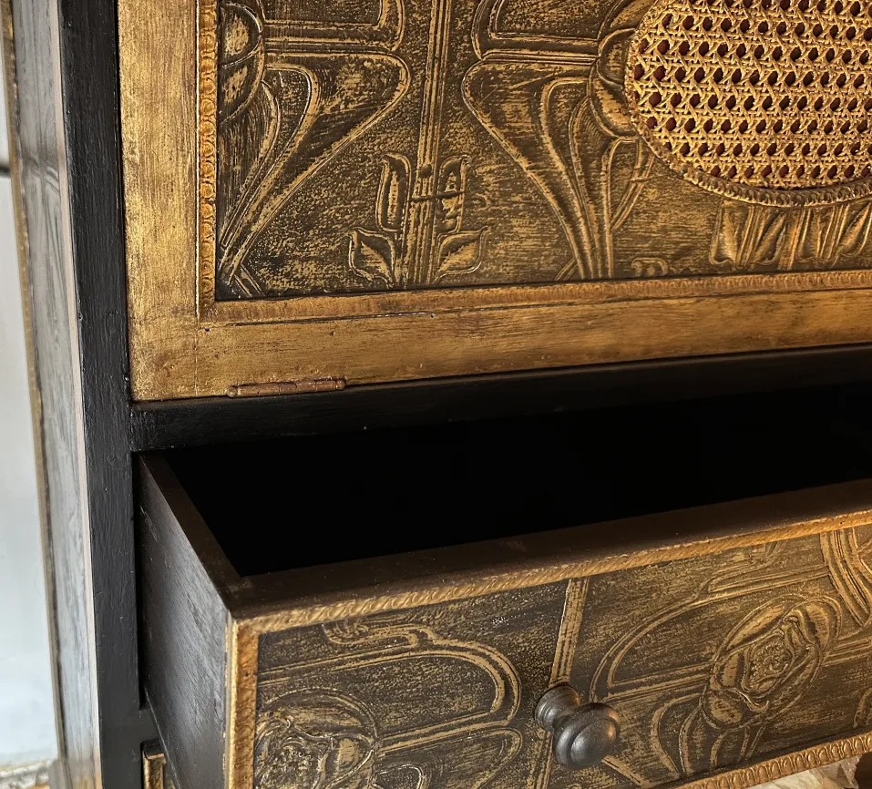 Meuble à cocktail ancien en tons dorés avec un design floral, comportant un tiroir ouvert.