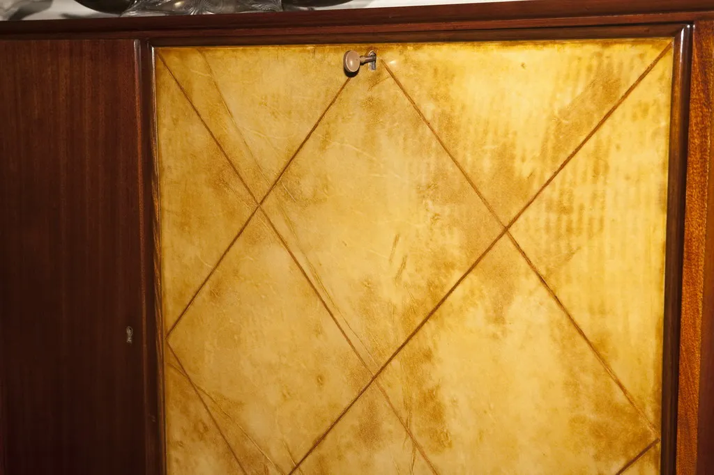 Vista dettagliata di una libreria antica con finitura art deco. Il colore prevalentemente dorato aggiunge un tocco elegante.