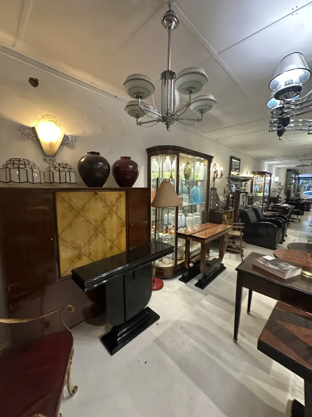 Antique bookcase in Art Deco style with elegant decorations, lamps, and period furniture.