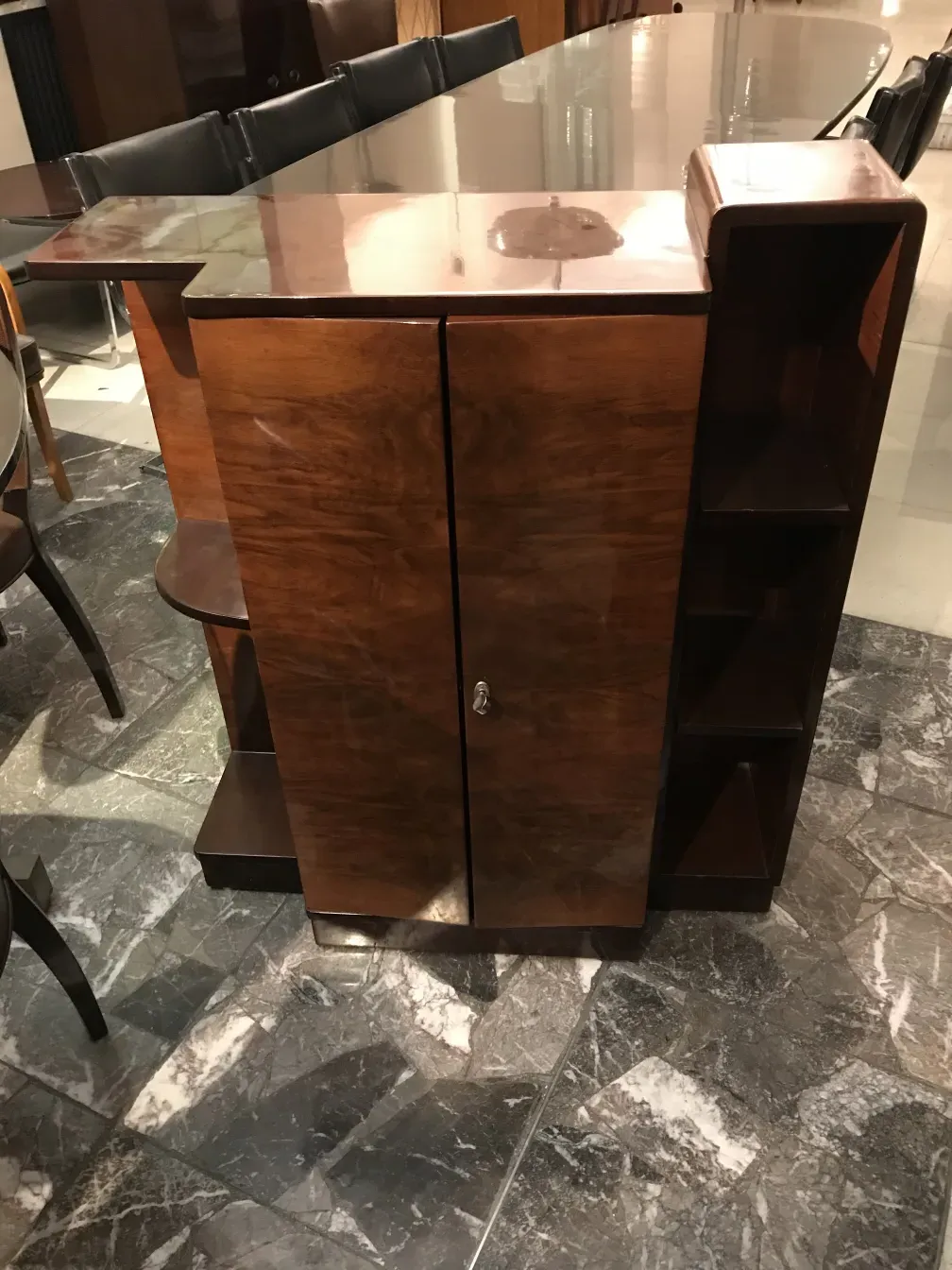 Antikes Bücherregal mit glänzender Oberfläche und sichtbaren Regalen in einer eleganten Umgebung.