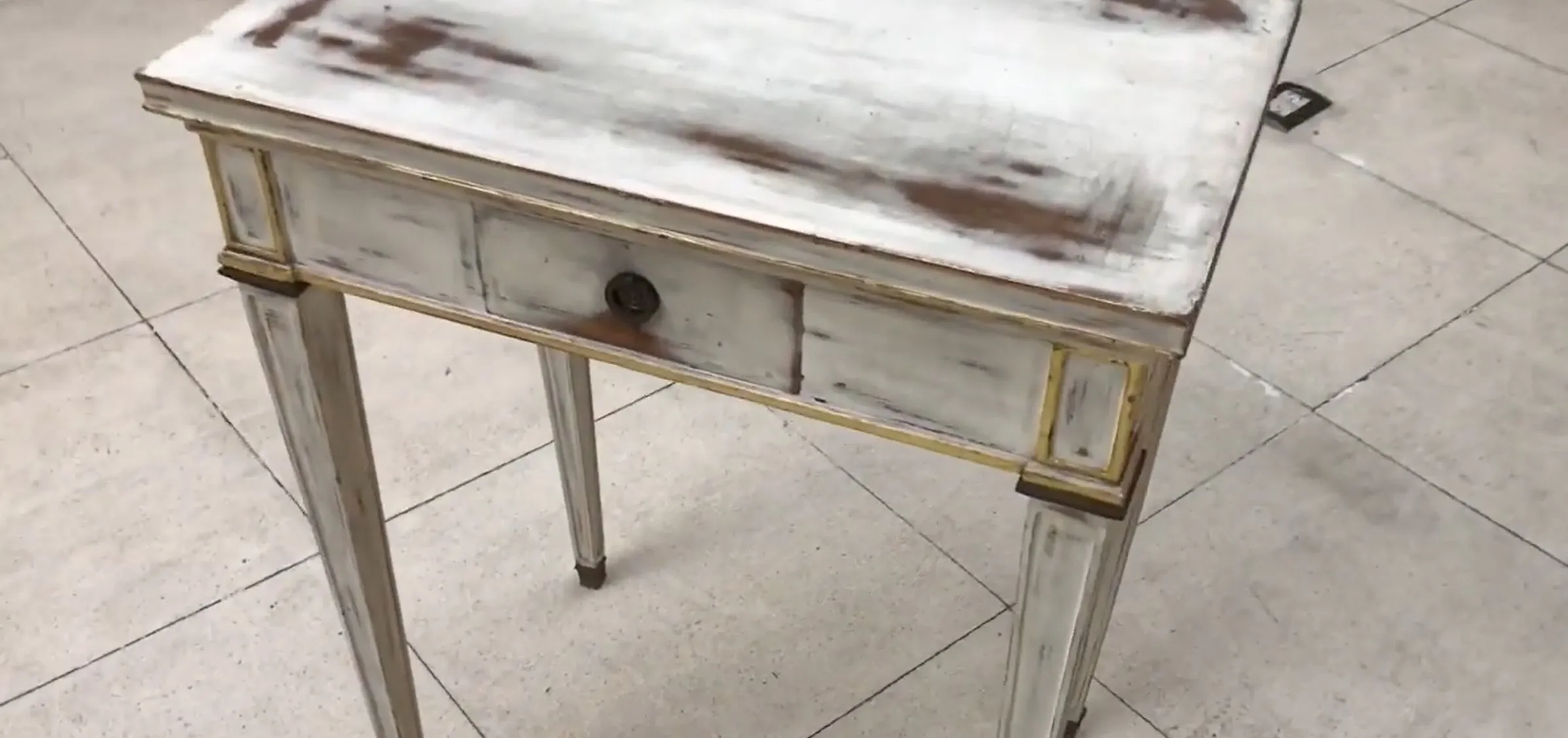 Antique desk with a weathered finish and a drawer