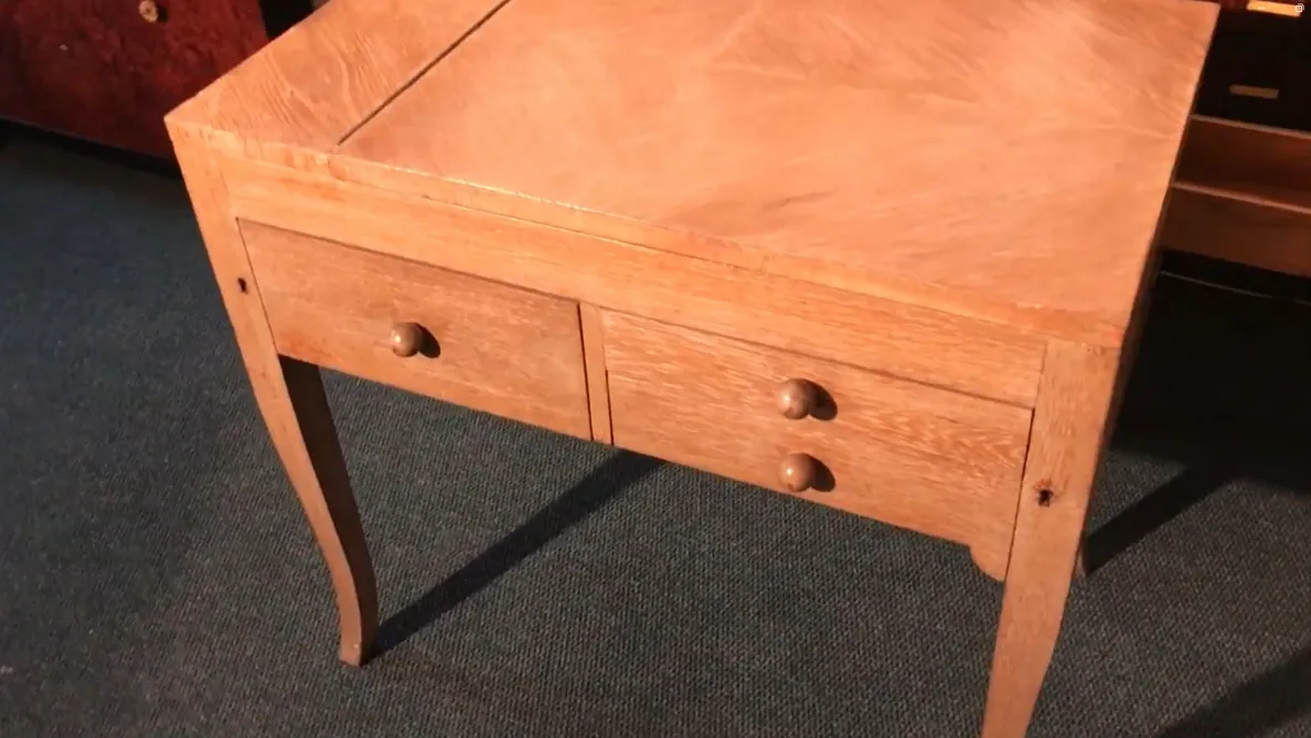 Antiker Holztisch mit zwei abgerundeten Schubladen in einem gemütlichen Ambiente.