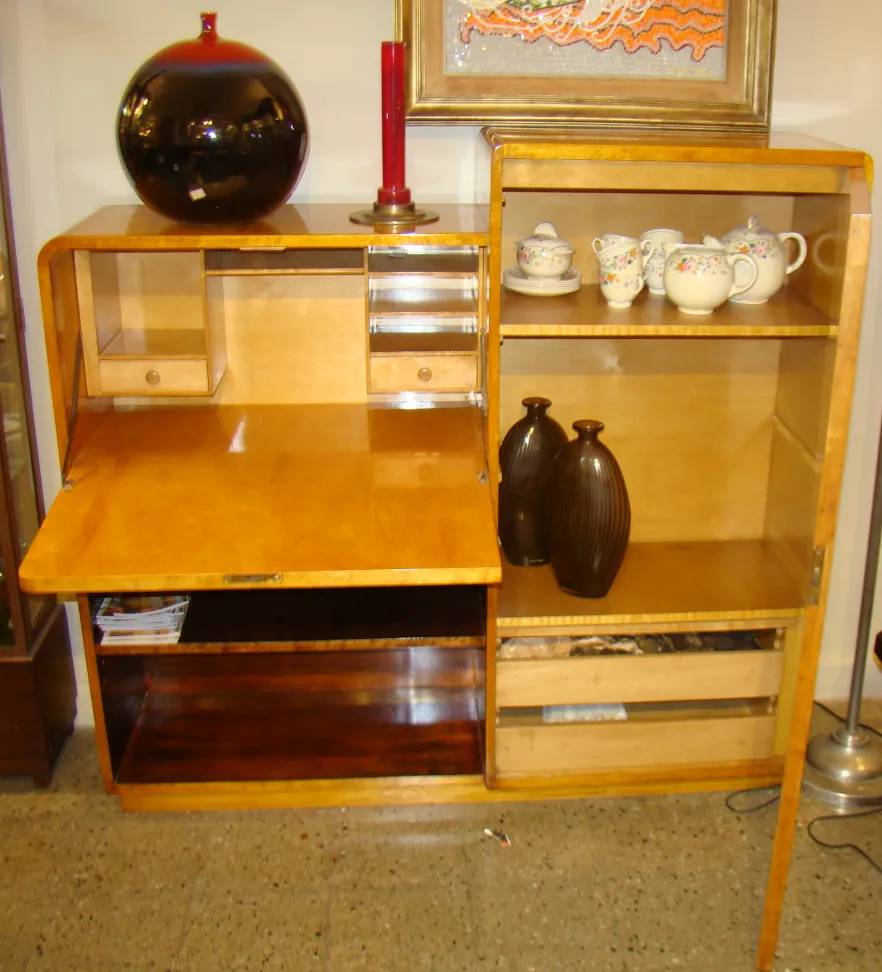 Bureau ancien en bois avec plusieurs compartiments et objets décoratifs.