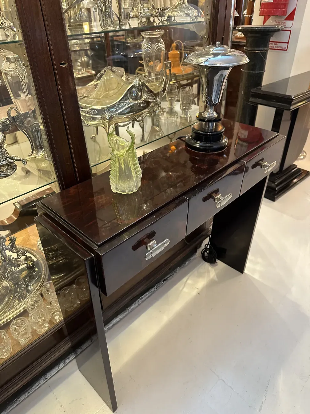 Visão de duas consoles antigas com acabamentos decorativos em um ambiente vintage