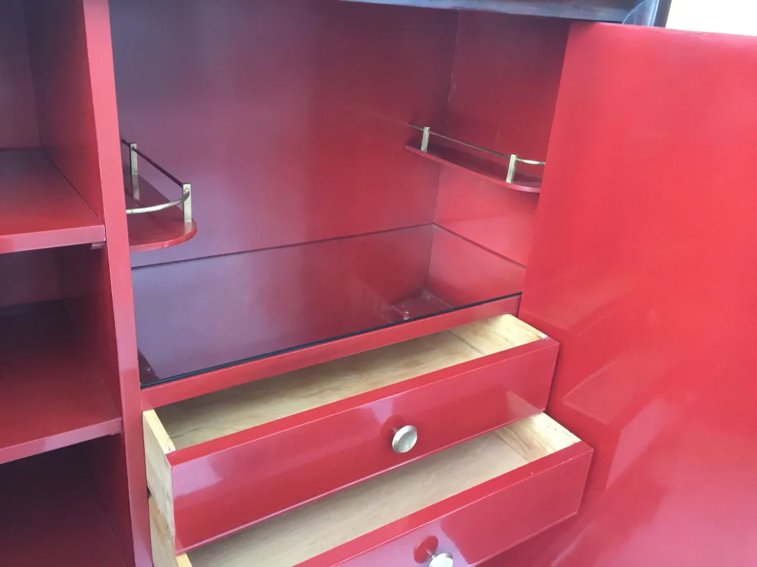 Biblioteca antigua roja con estantes visibles y cajones