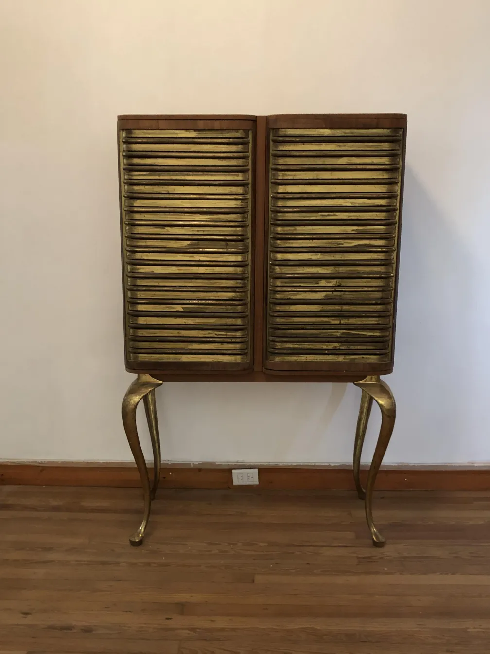 Antique bar cabinet with golden finish and stylish legs.