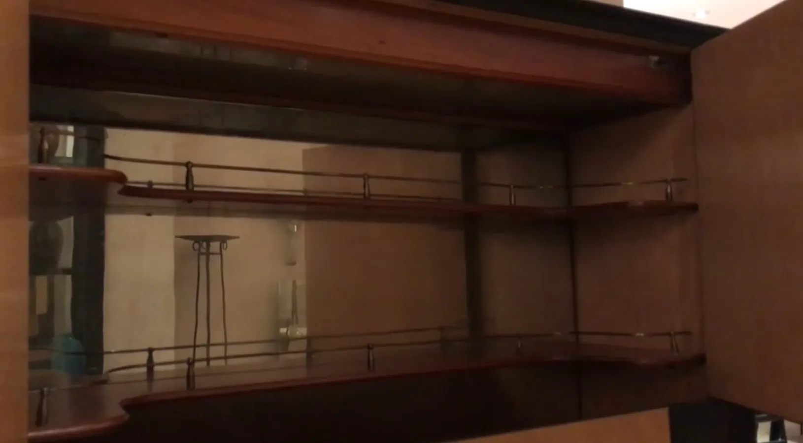 Mueble bar antiguo con estantes y acabados en madera, ambiente acogedor.