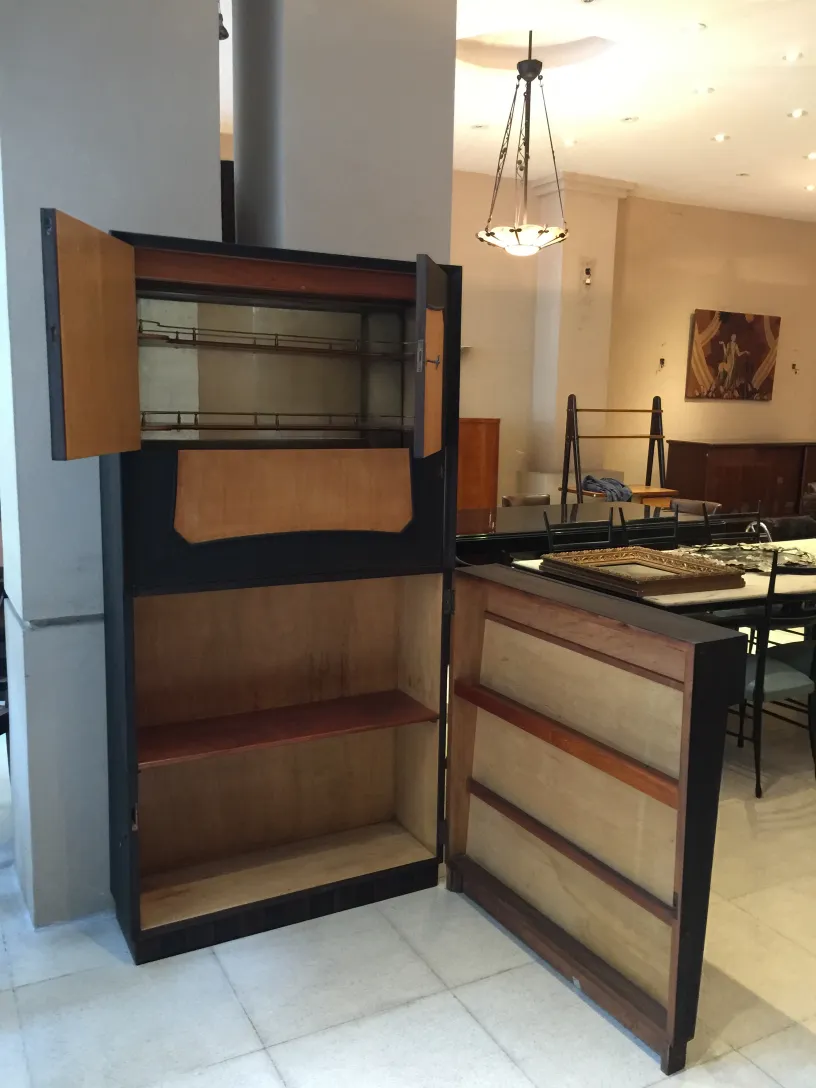 Antique bar cabinet with classic design and various shelves in a modern setting.