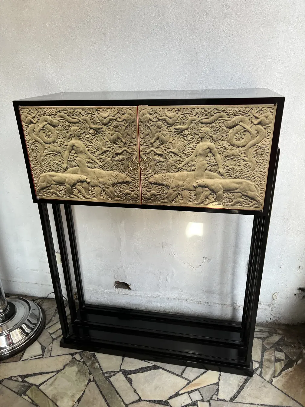 Eleganter antiker Cocktailschrank mit künstlerischen Reliefs und hellem Hintergrund