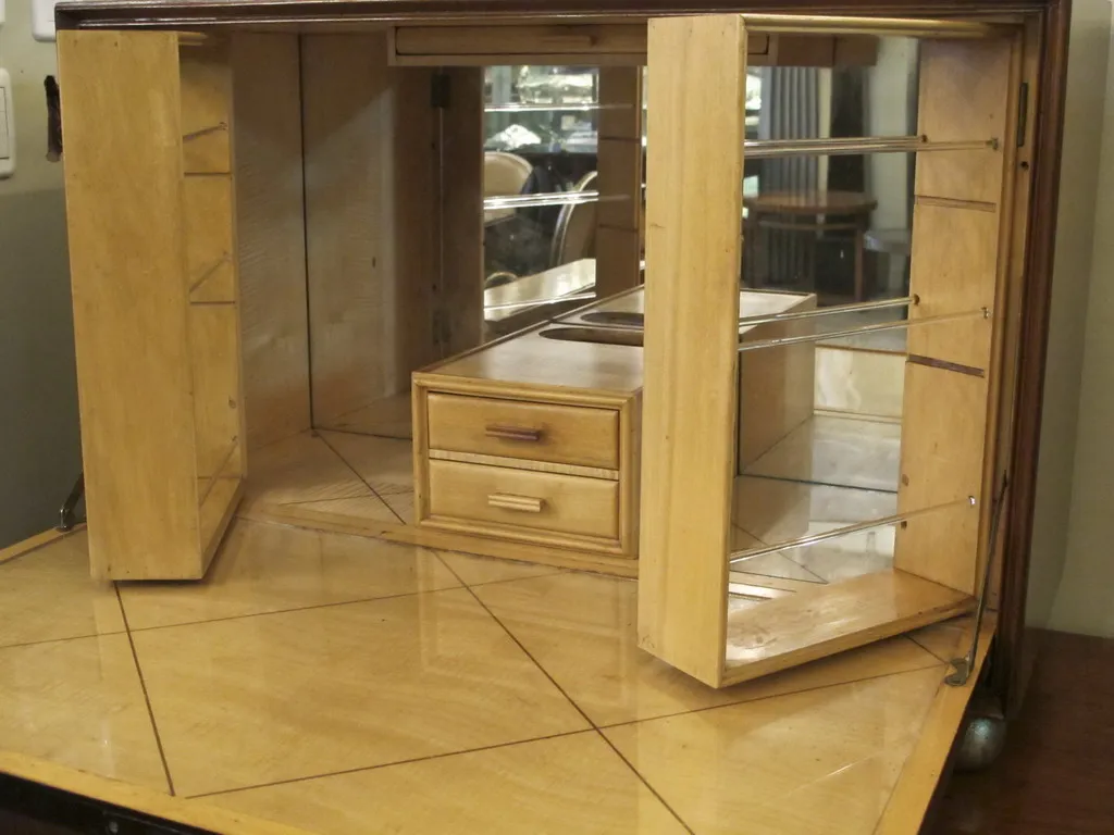 Antique bar cabinet with mirrors, shelves, and drawers.
