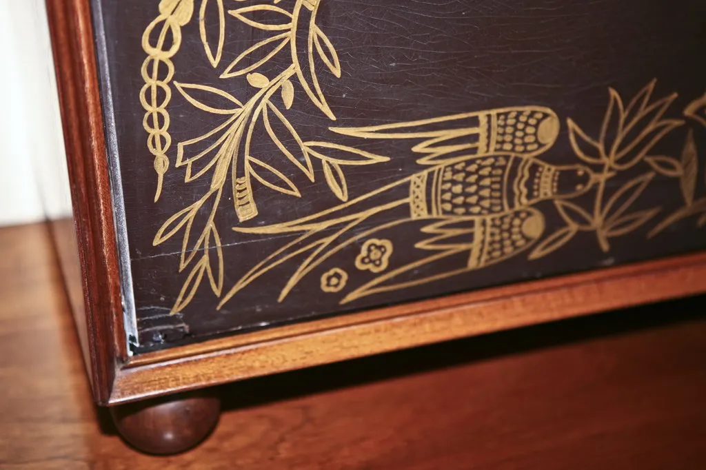 Mueble bar antiguo decorado con motivos naturales, ideal para ambientes elegantes.