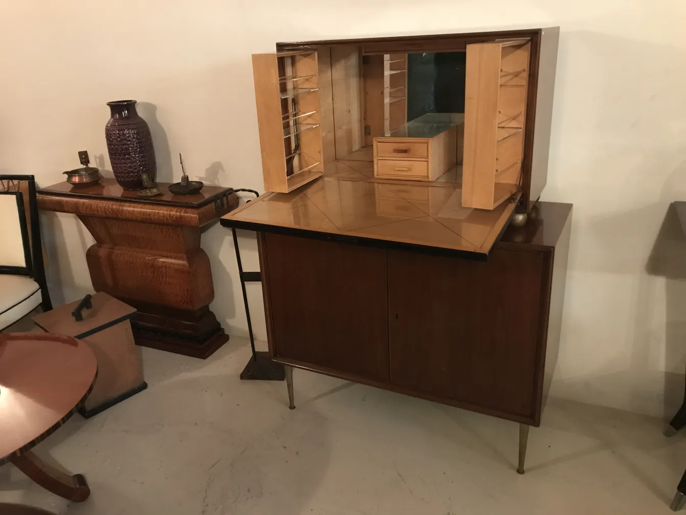 Antique bar cabinet with wooden details and space for glasses.