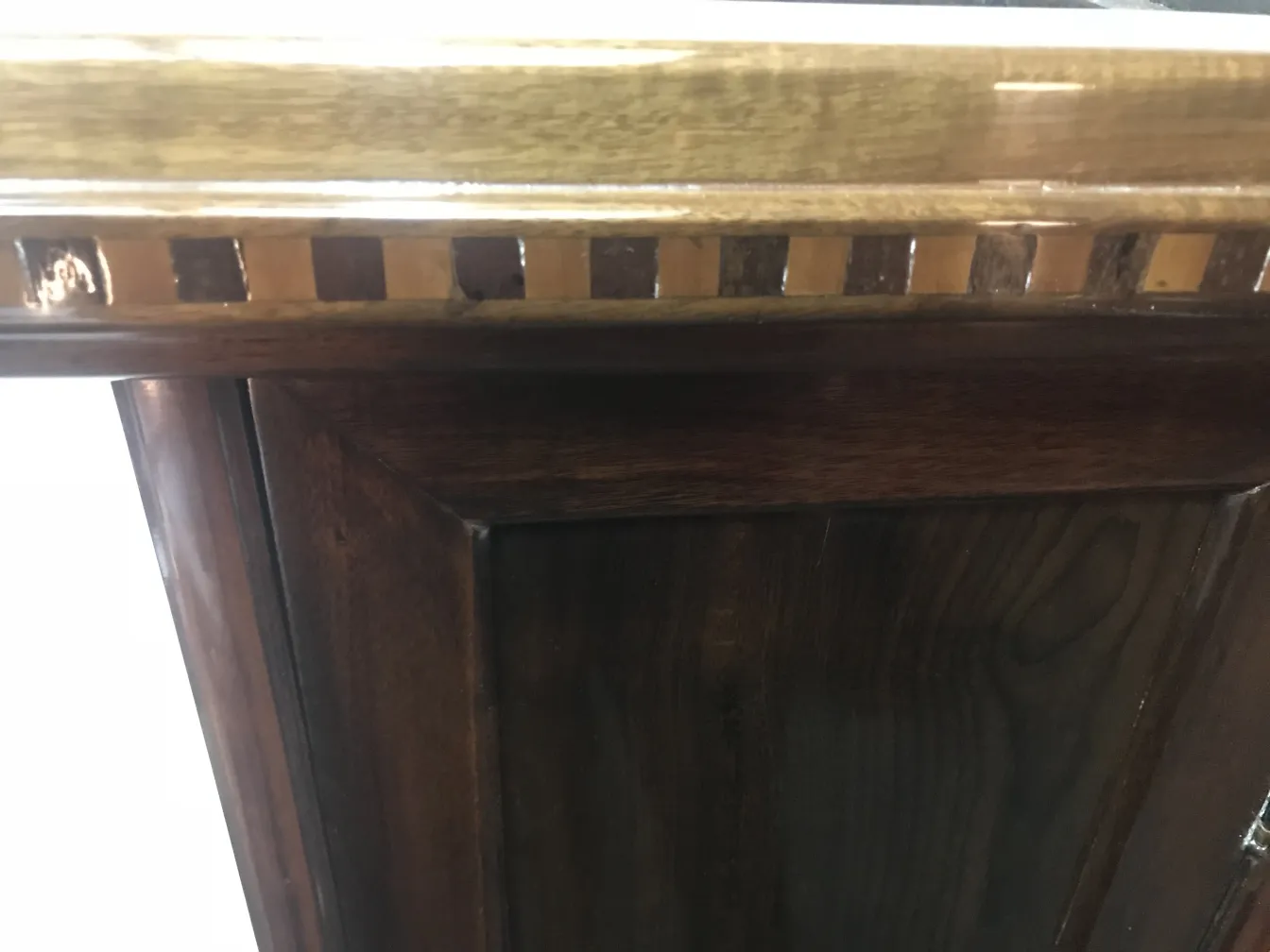 Coluna antiga com detalhes ornamentais, fundo neutro.