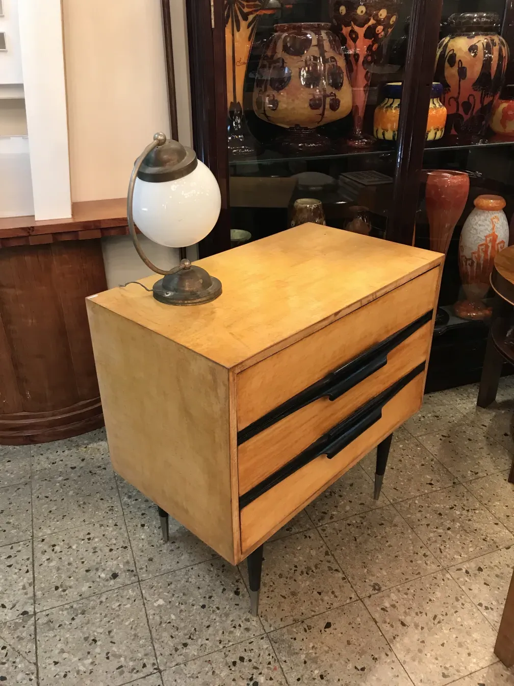 comodino antico con cassetti e lampada decorativa, ambiente con vasi in ceramica