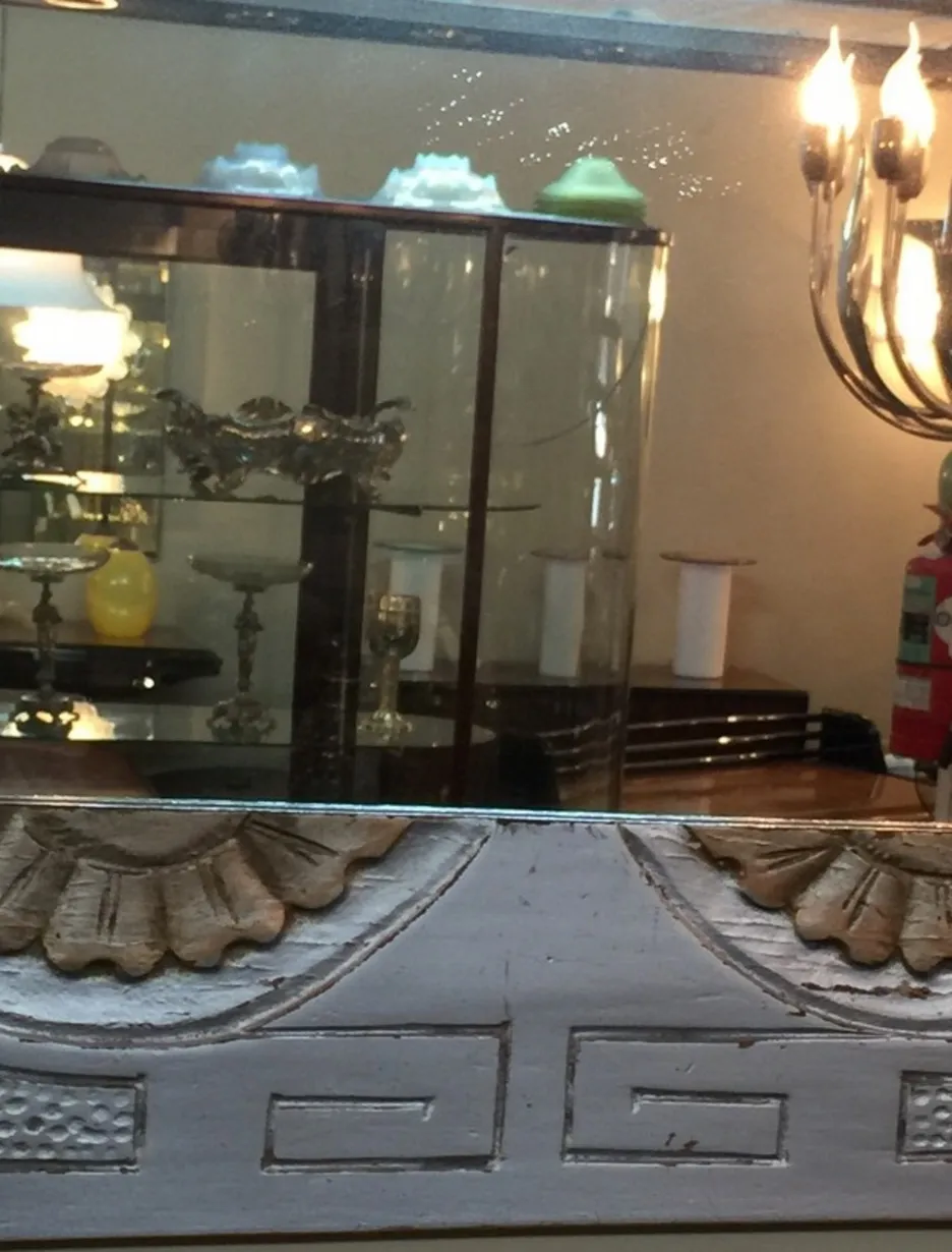antique mirror with decorative details, reflecting an elegant setting