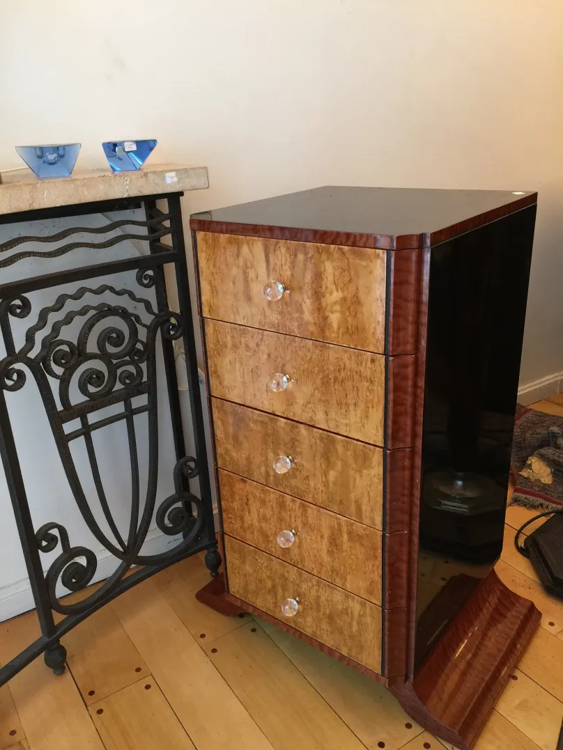 Старинный деревянный шкаф с четырьмя ящиками, украшенный стеклянными ручками.