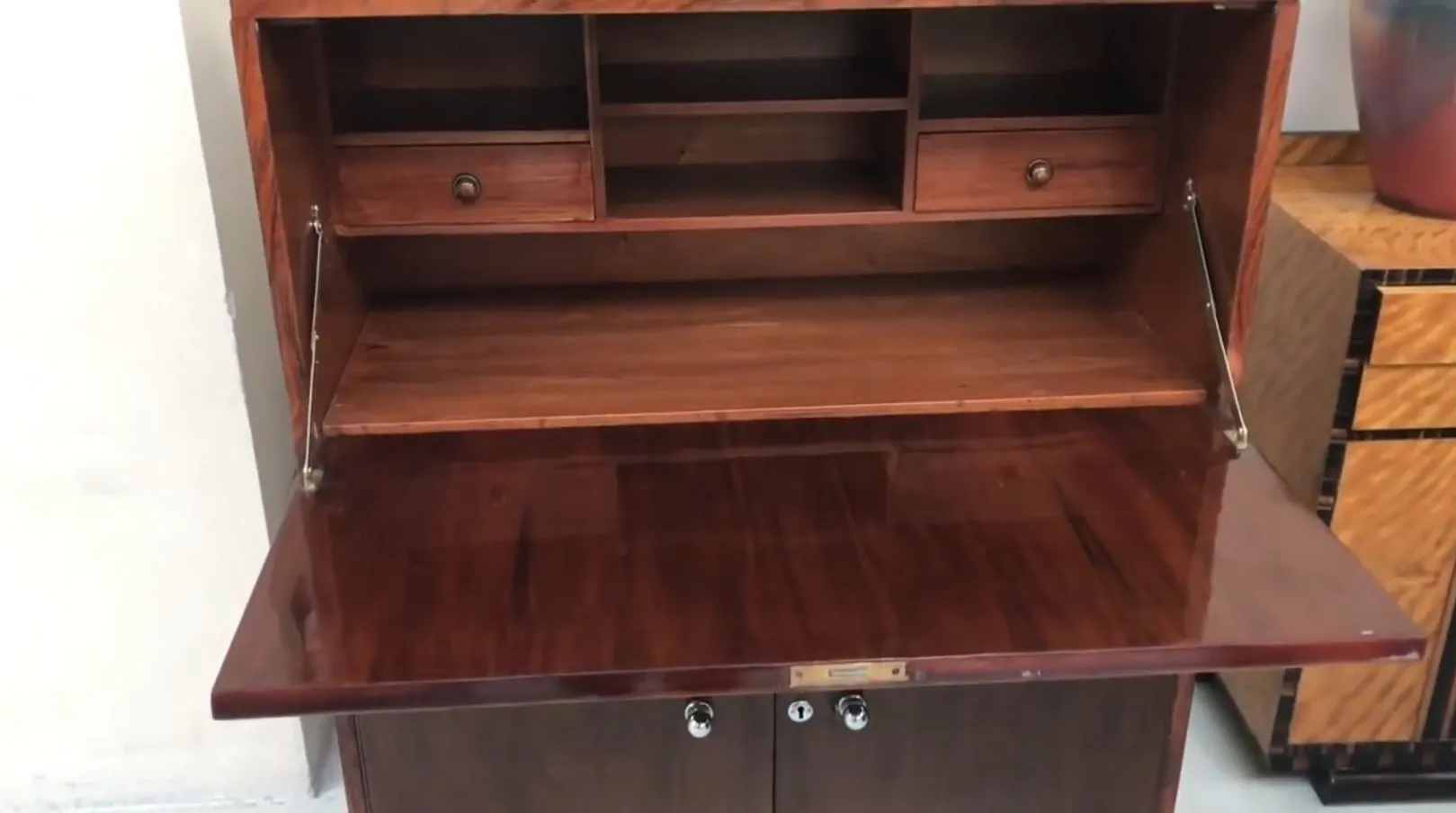 Escritorio antiguo con dos cajones y estantes visibles.