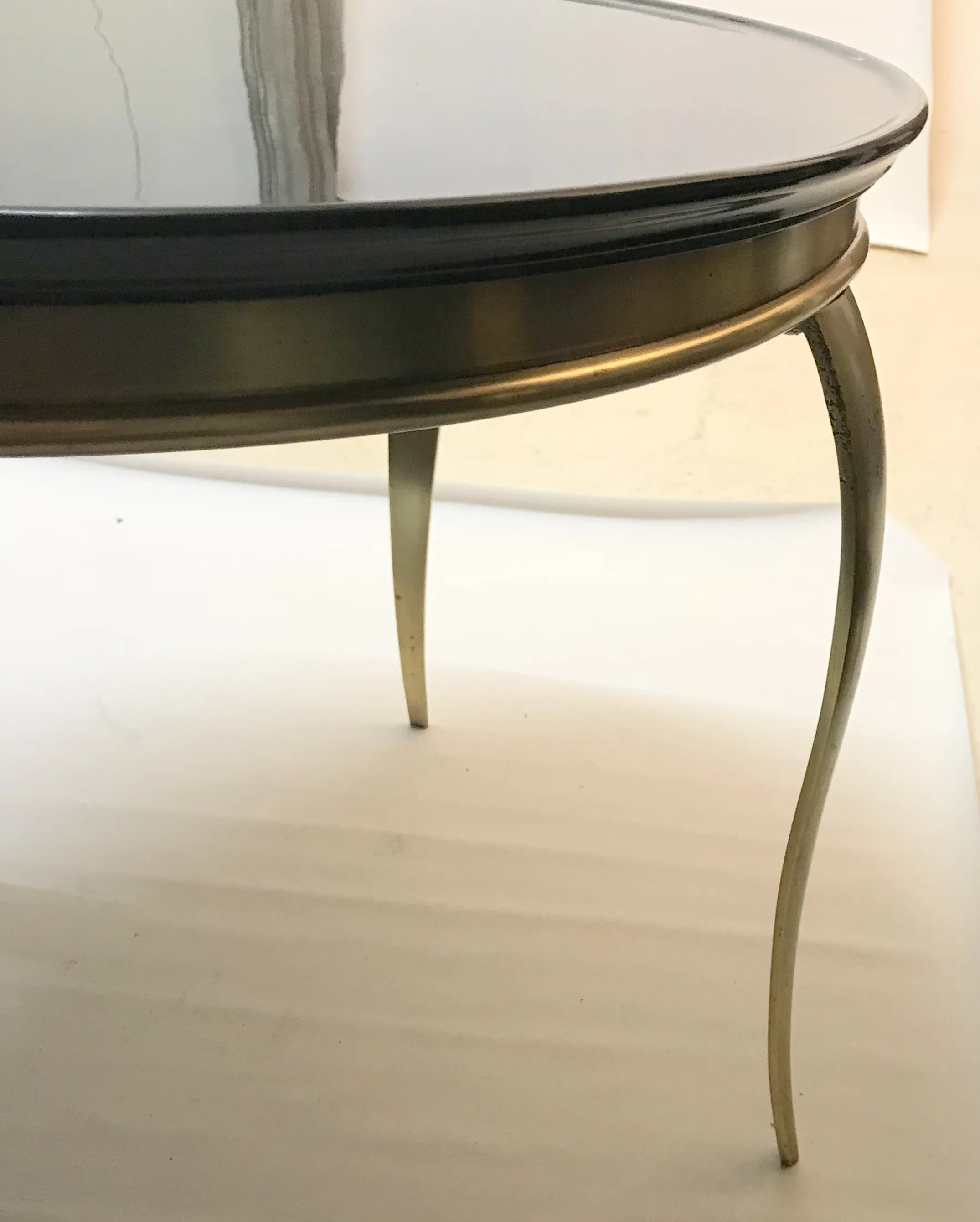 antiker Couchtisch mit eleganten Beinen und runder Form in einer minimalistischen Umgebung