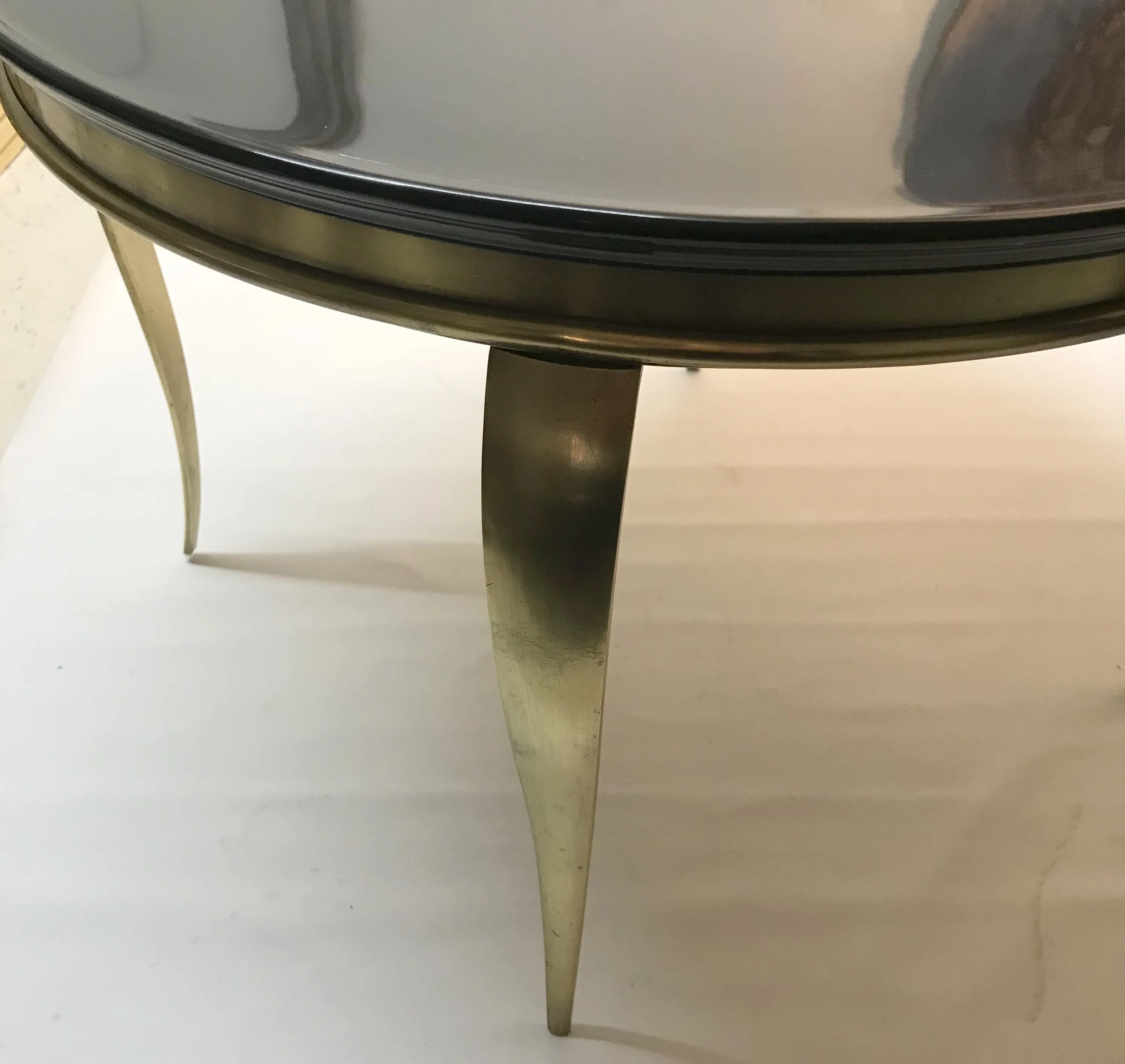 Mesa ratona antigua con patas doradas y superficie lisa, en ambiente claro.