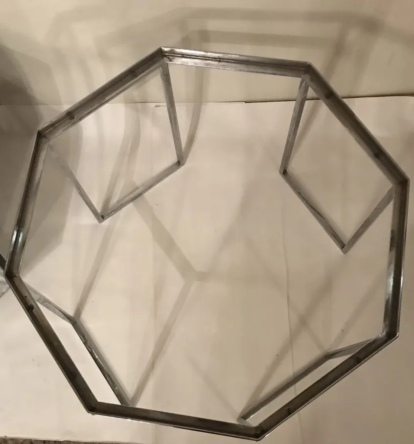 antique coffee table with an octagonal design and metal frame, set in a neutral environment.