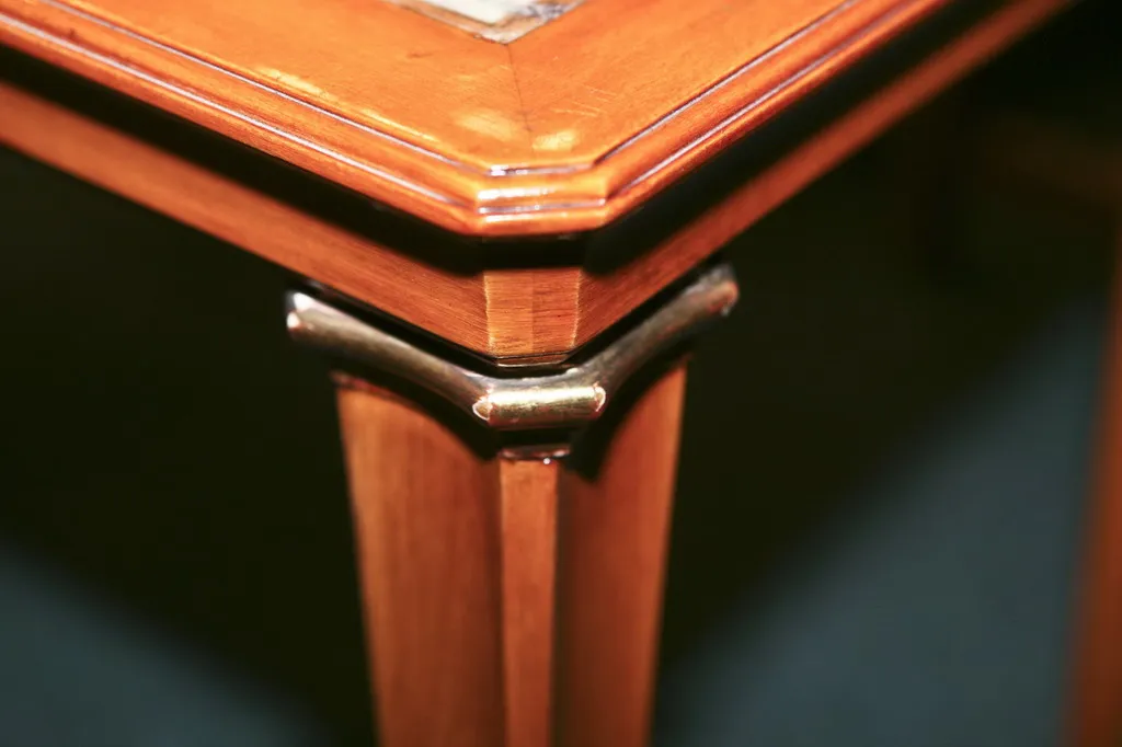 Mesa de centro antiga com detalhes elaborados e pernas decorativas