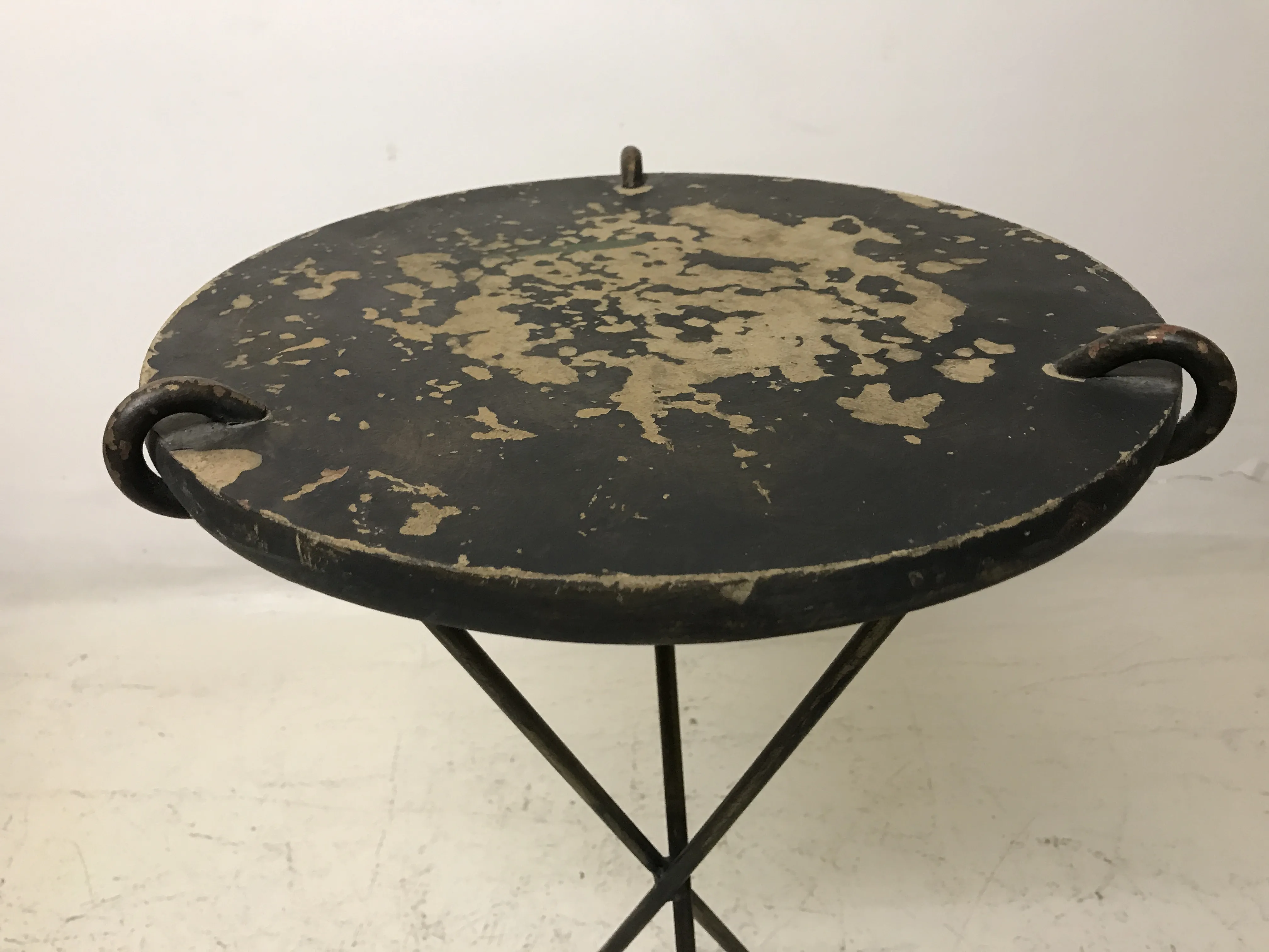 mesita antigua redonda con superficie decorativa desgastada