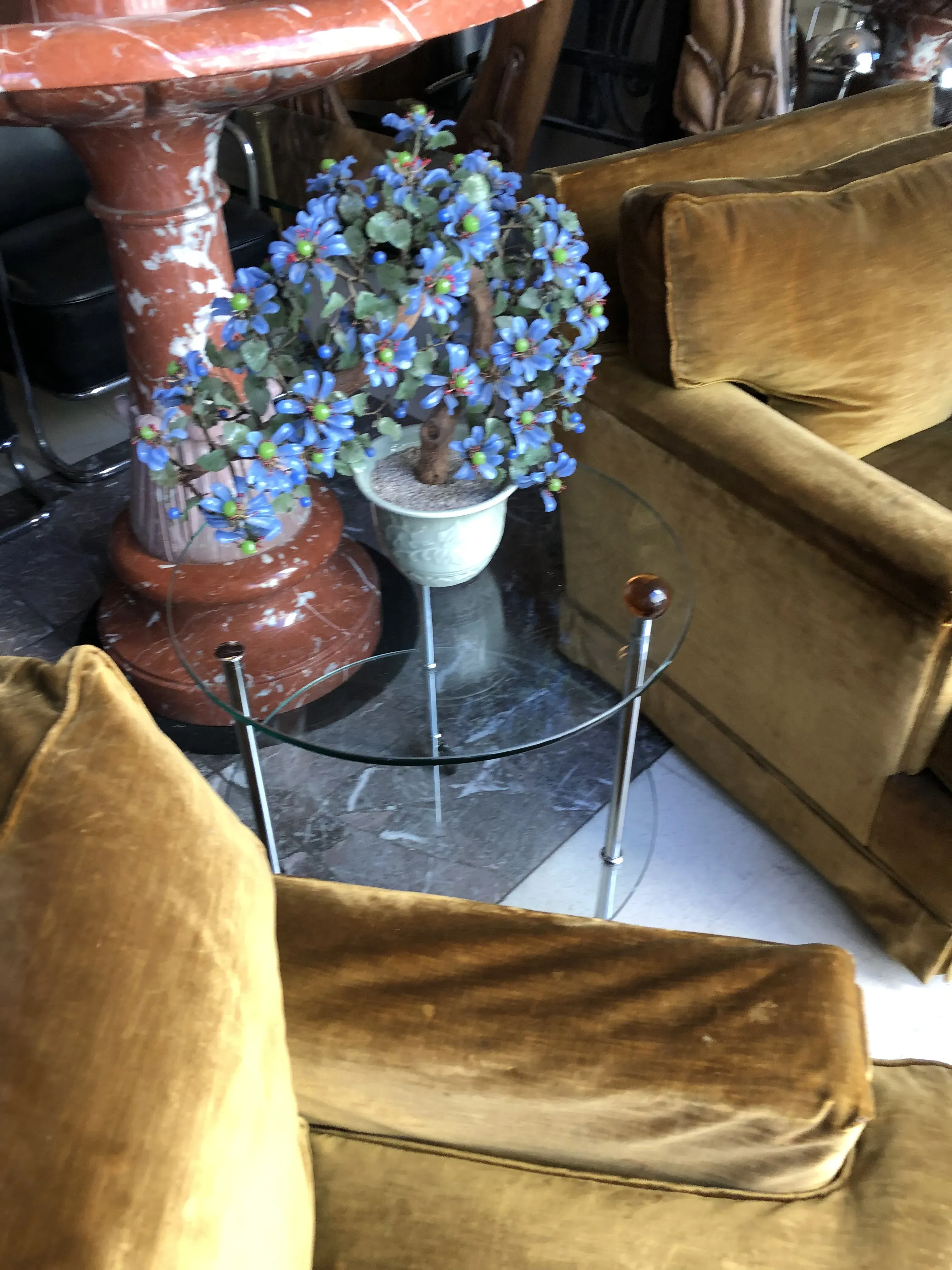 Petite table ancienne avec des fleurs artificielles et des fauteuils jaunes