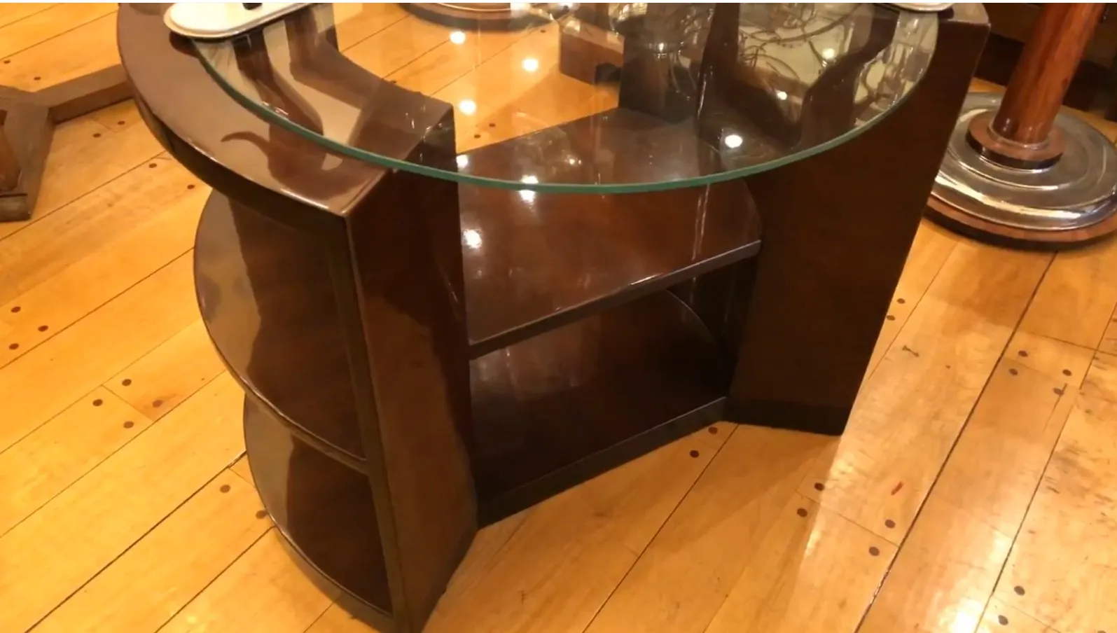 Tavolo antico in stile Art Deco con ripiani e forma curva.