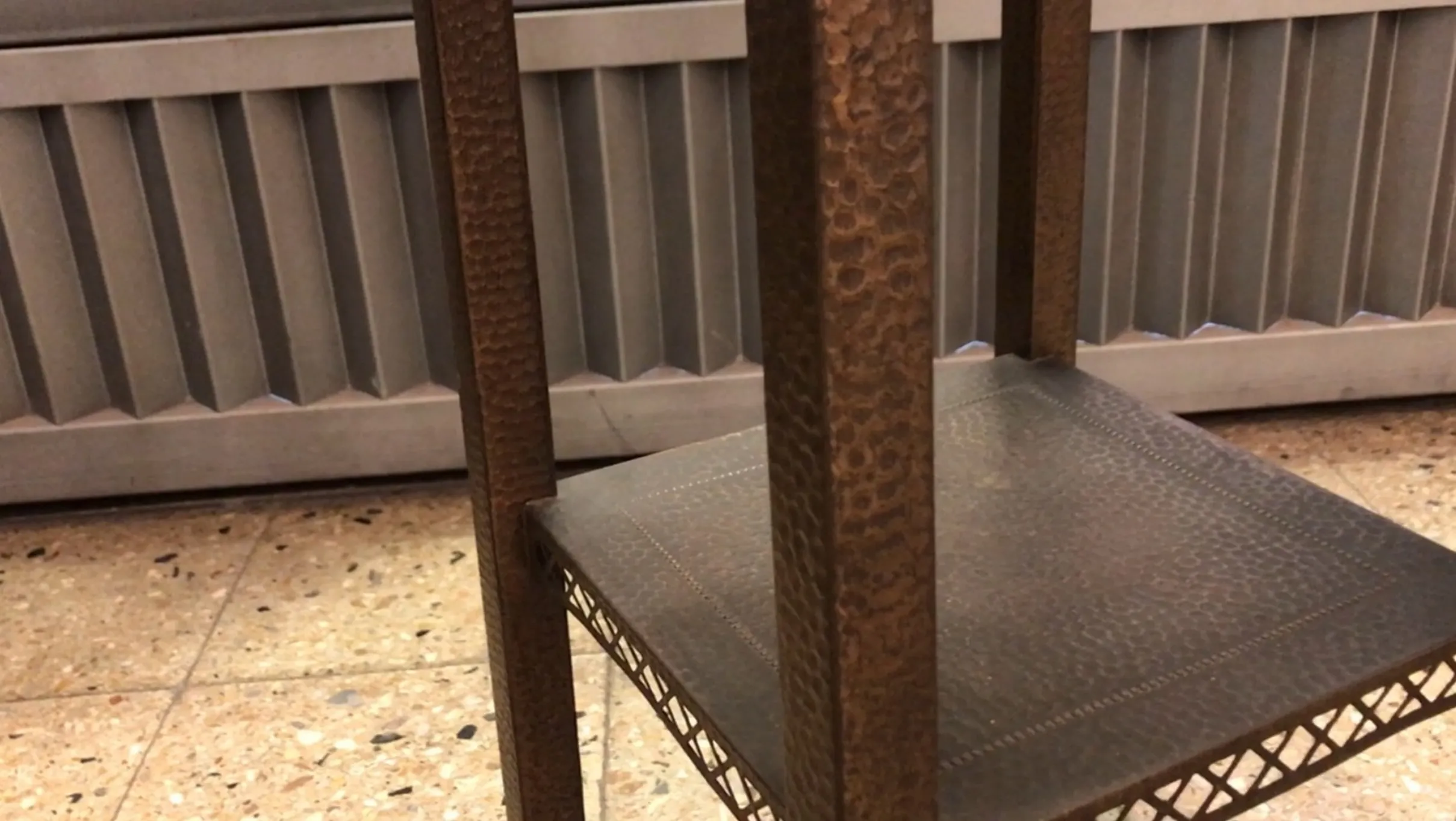 Mesinha antiga baixa com detalhes em superfície em ambiente.