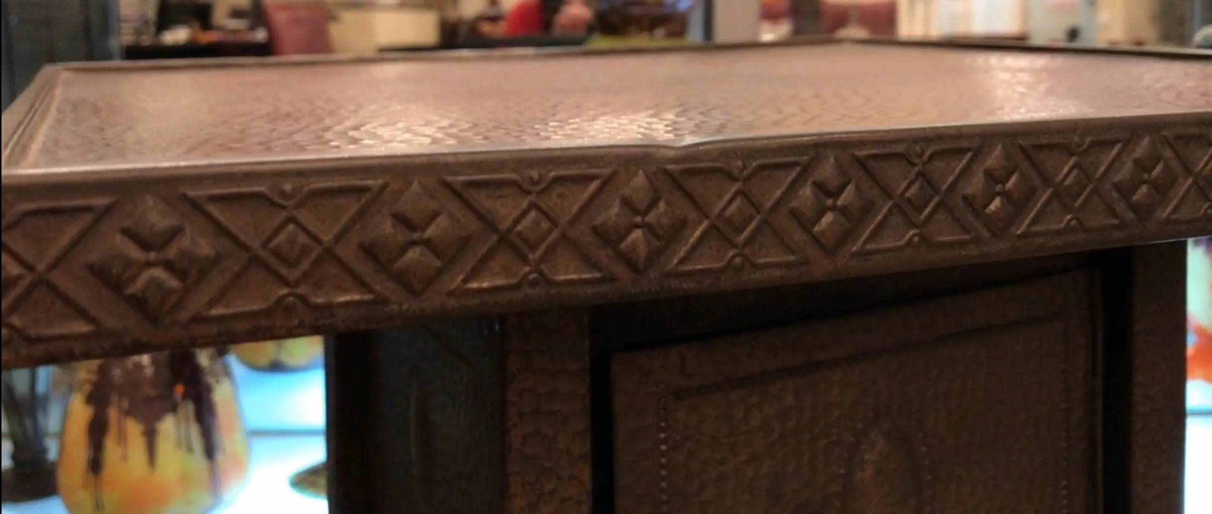 Petite table ancienne avec des détails décoratifs en haut