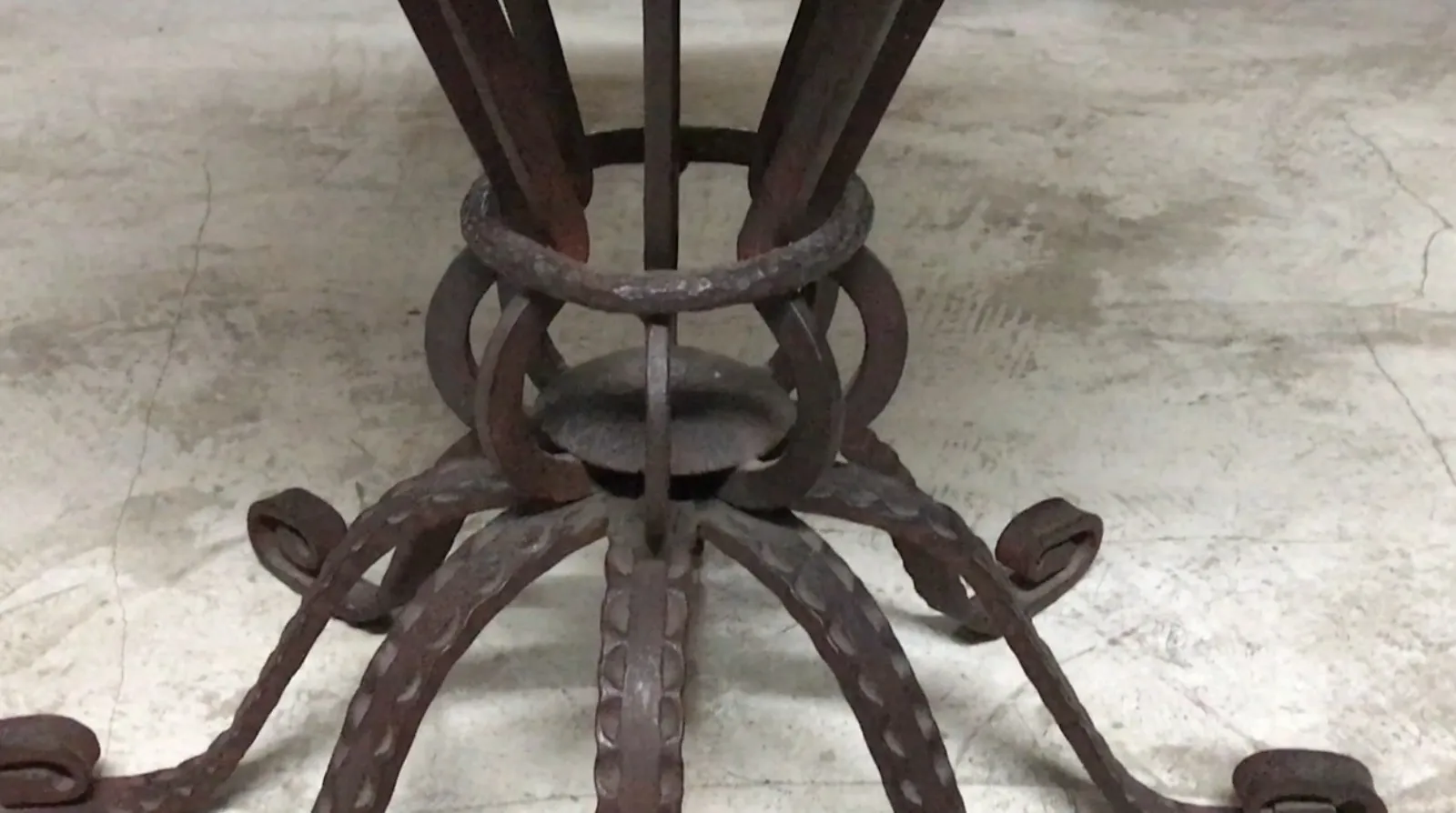 mesa antigua de estilo Art Deco con forma detallada en hierro.