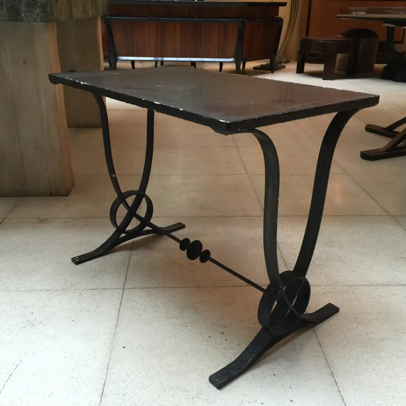Mesa antigua Art Deco con diseño elegante y curvado, en un ambiente sólido.