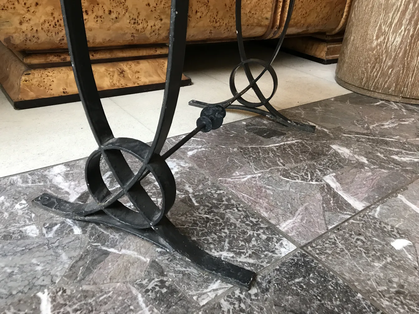 Mesa antigua con un elegante diseño art deco en la base, rodeada de un ambiente moderno.