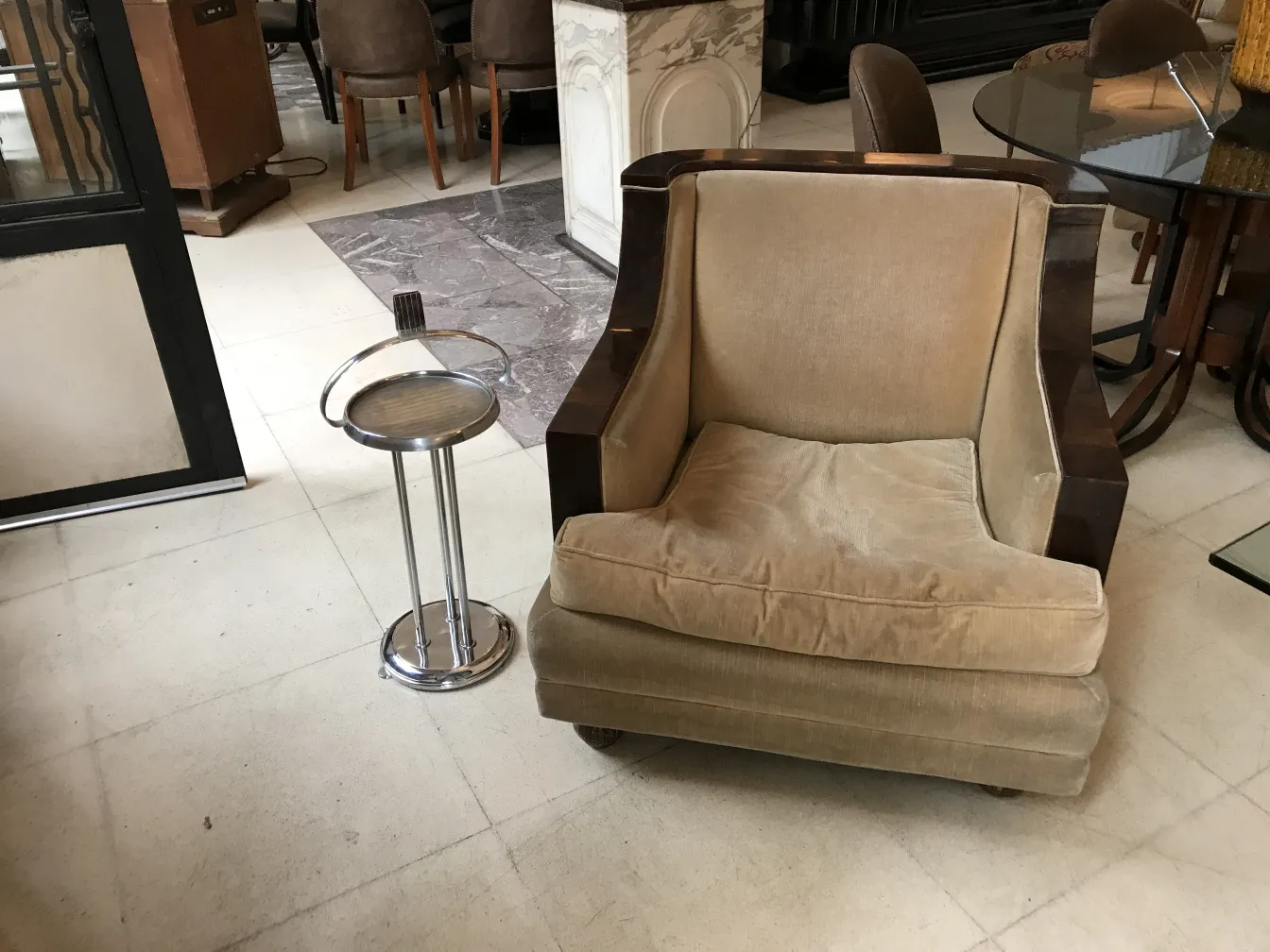 antique small table next to a brown armchair