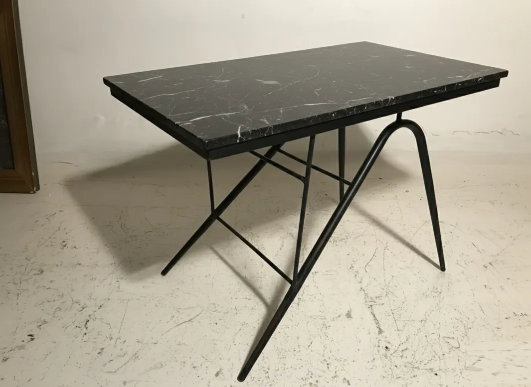 mesa antiga de jardim com tampo preto e pernas de metal