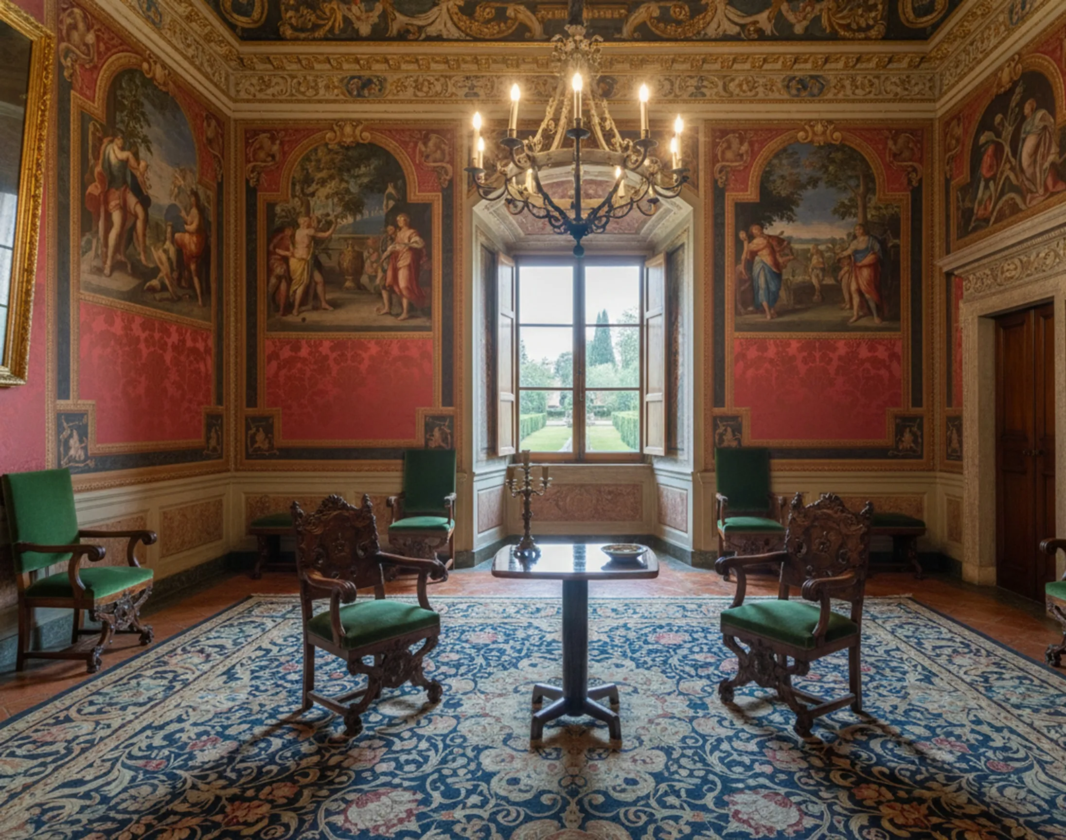 Mesita antigua de diseño clásico en un salón elegante con paredes pintadas y sillas verdes.