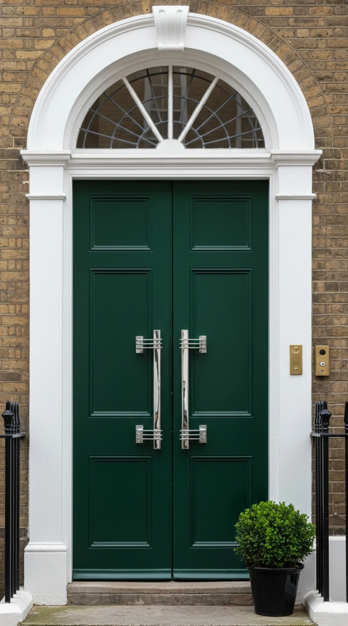 maniglie delle porte antiche verde scuro con design elegante, accanto a una pianta decorativa