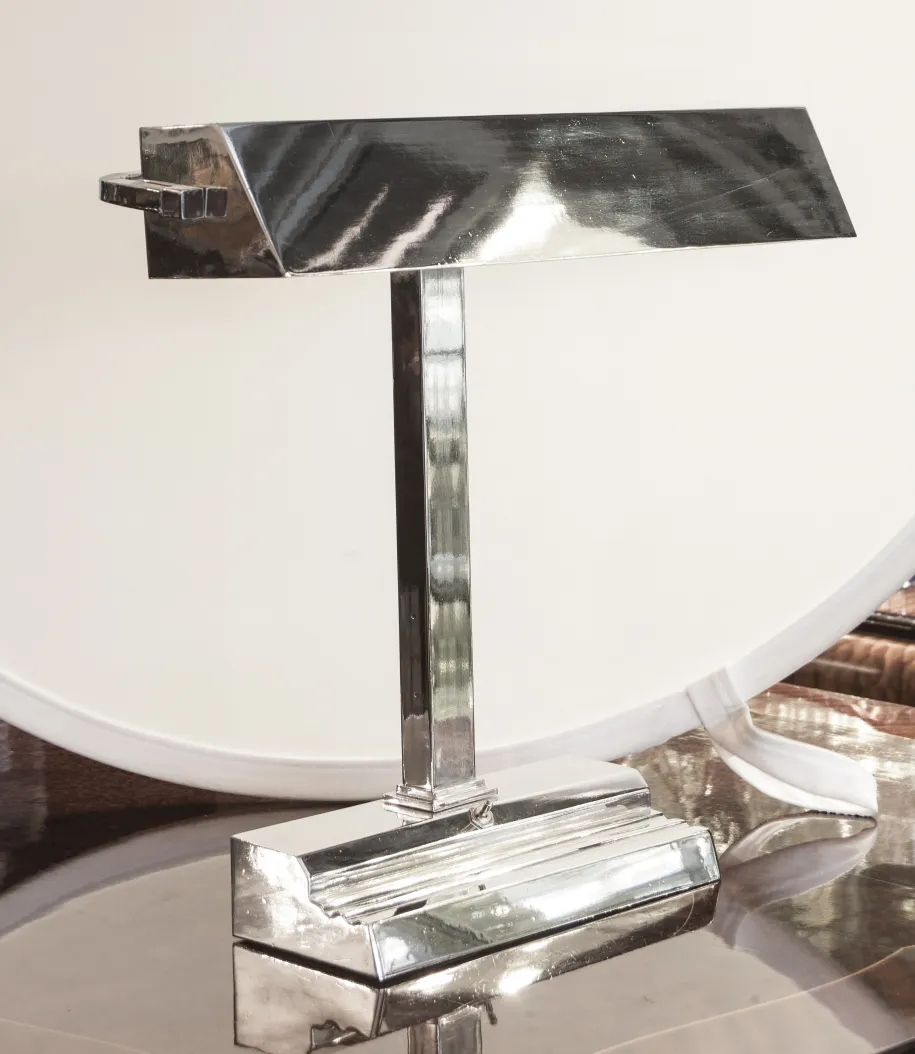 Antike Tischlampe im Art Deco-Stil mit glänzendem Sockel und elegantem Design in moderner Umgebung.