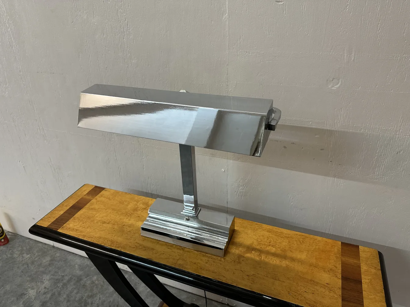 Lampe de bureau ancienne Art Deco sur une table en bois clair.