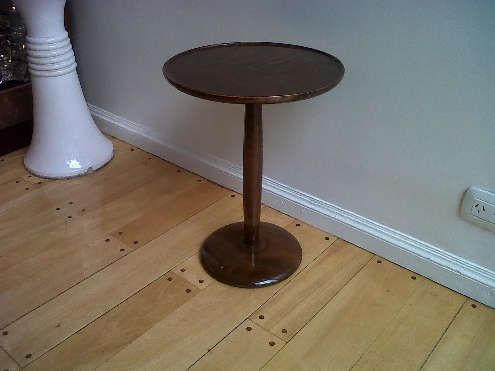 mesa antigua de pie redonda en un ambiente moderno