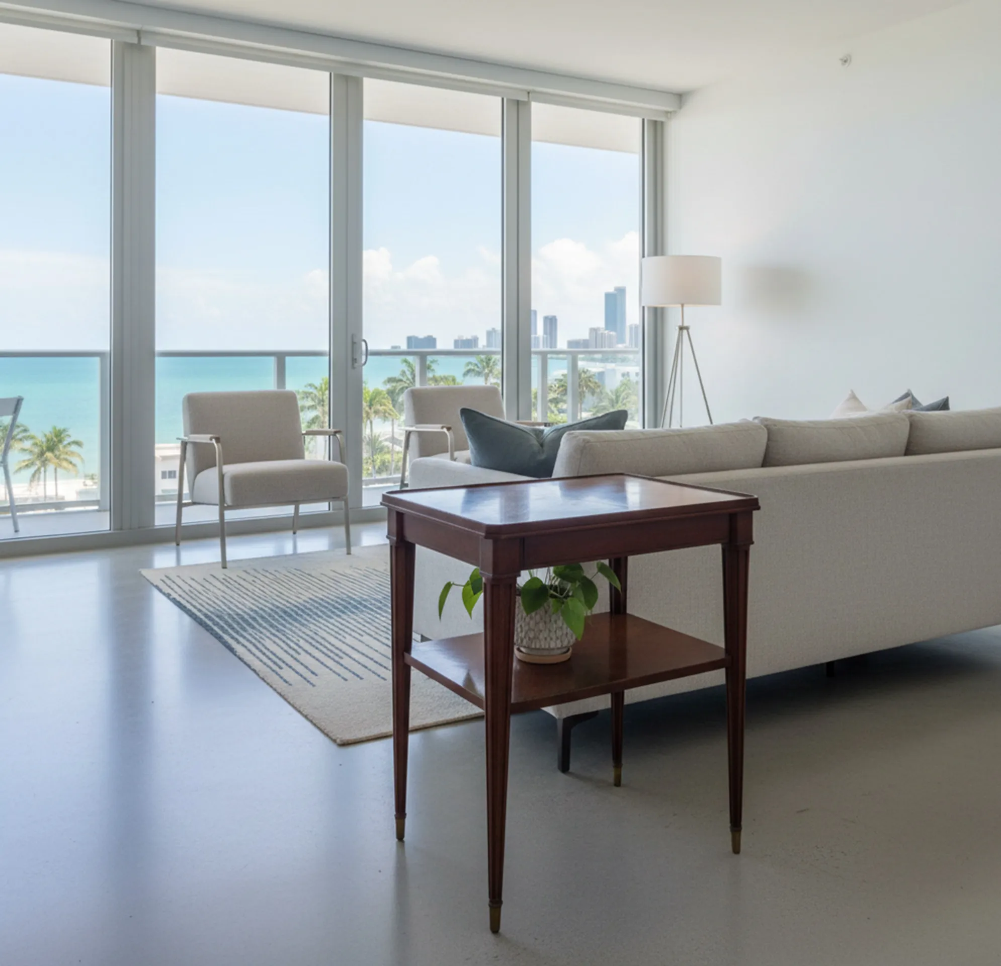 طاولة صغيرة قديمة مع رف سفلي، مزينة بنبتة، في غرفة معيشة حديثة ومشرقة