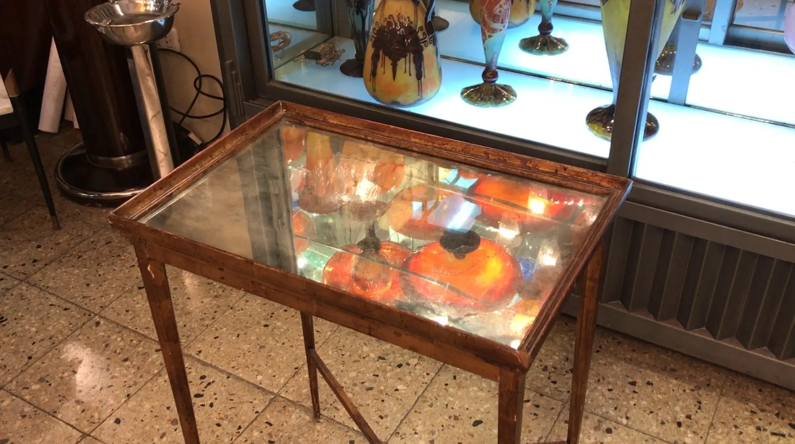 Antique table Chanaux et Pelletier with unique design and glossy surface, surrounded by decorative items